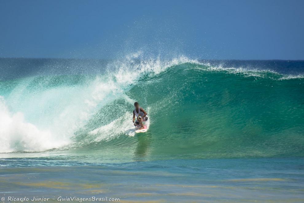 Imagem de surfista aguachado na prancha em Fernando de Noronha.